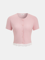 Light pink ribbed short sleeve cardigan with white lace hem and pearl-like buttons.