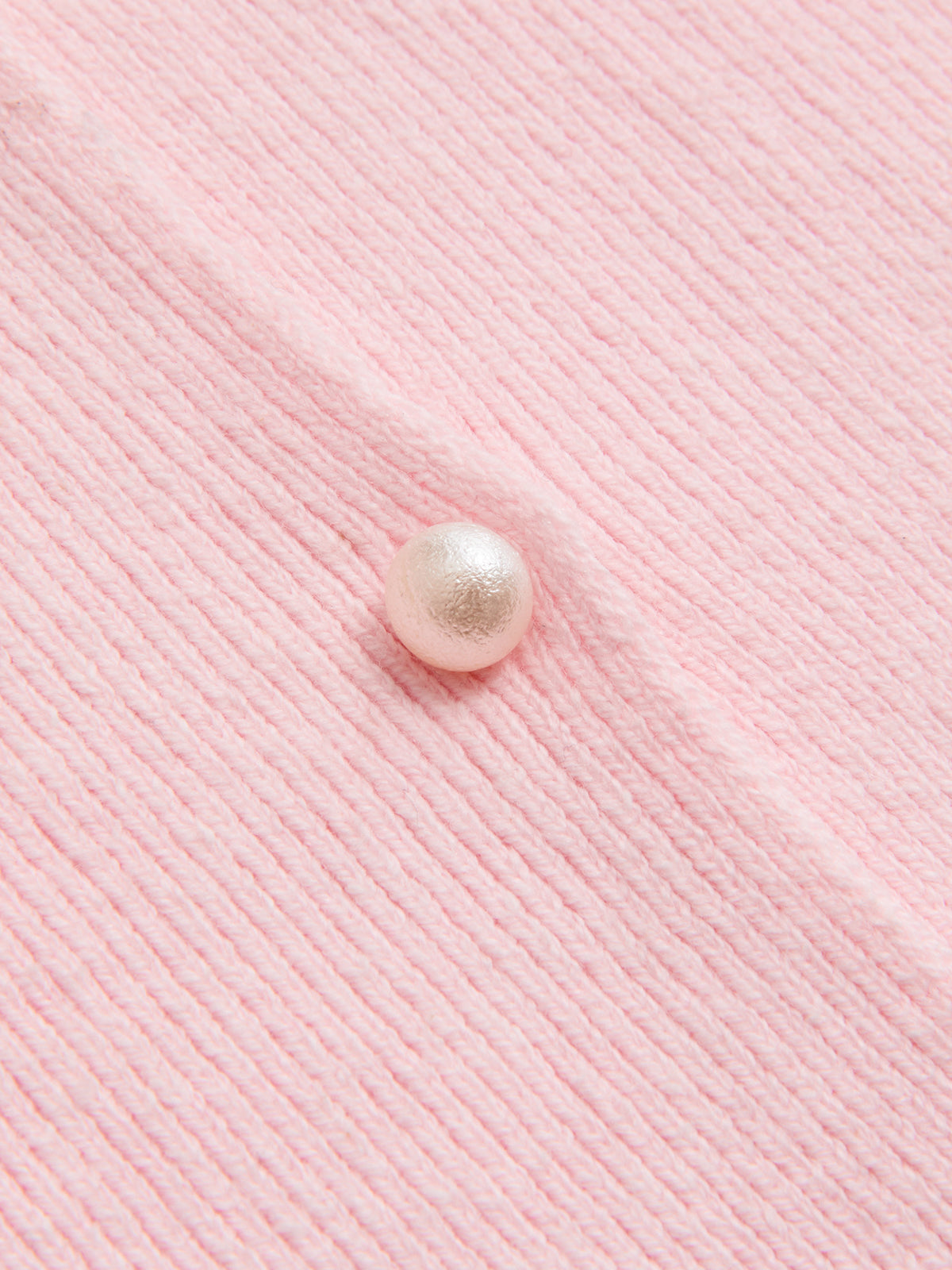 A ribbed pink cardigan with lace trim and a single pearl button on the front.